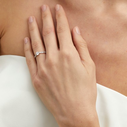 Elegante anillo solitario acompañado de oro blanco 18K rodeado por un pavimento de circonita