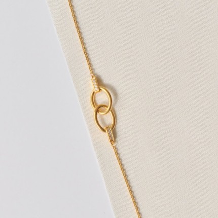 Pulsera bañada en oro con circonitas y anillos entrelazados