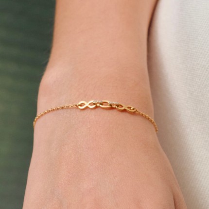 Pulsera bañada en oro con circonitas y motivos de infinito