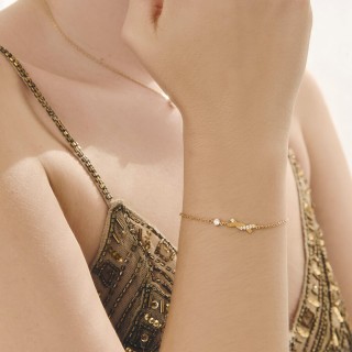 Pulsera bañada en oro con siete circonitas y motivo cruzado
