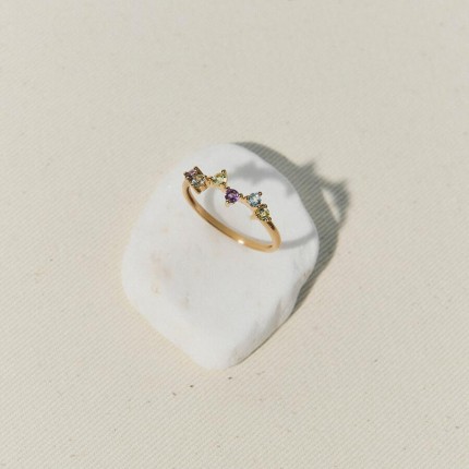 Um anel em ouro amarelo 9K adornado com duas topázios azuis, duas ametistas e dois peridotos, engastados com três garras